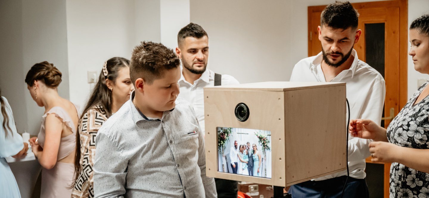 Hostia na svadbe s rekvizitami pred fotobúdkou